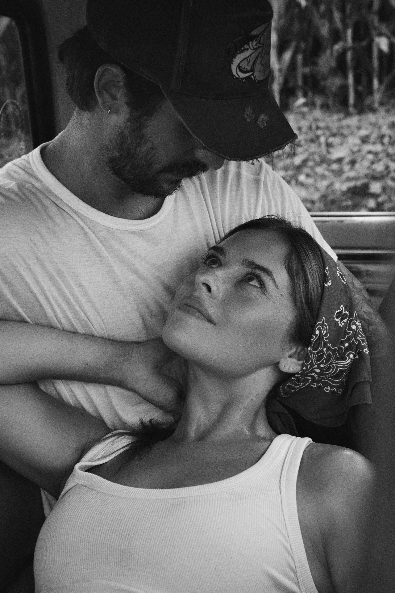 A close, black and white portrait of a couple in the back of a truck