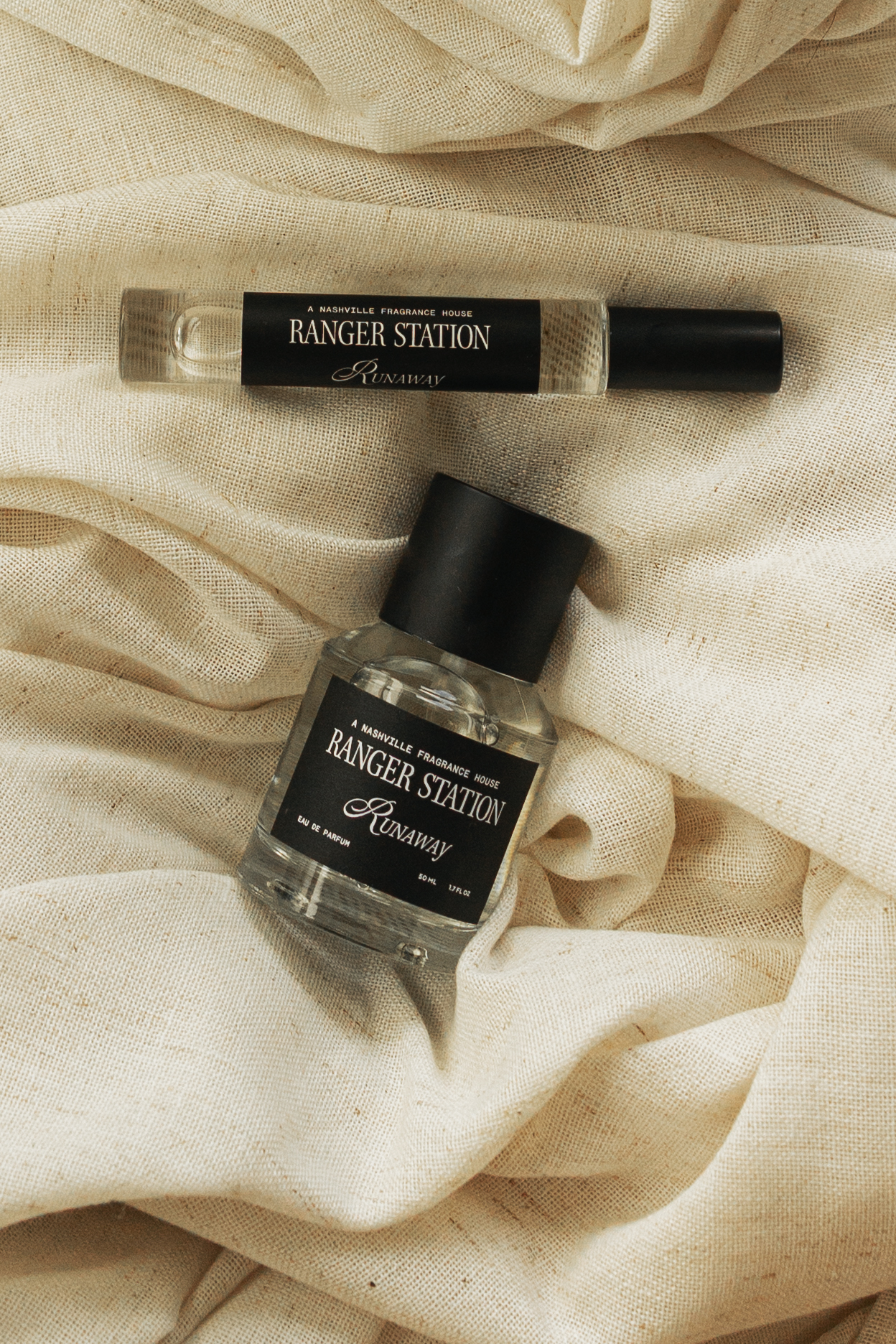 Two Ranger Station Runaway bottles resting on cream linen